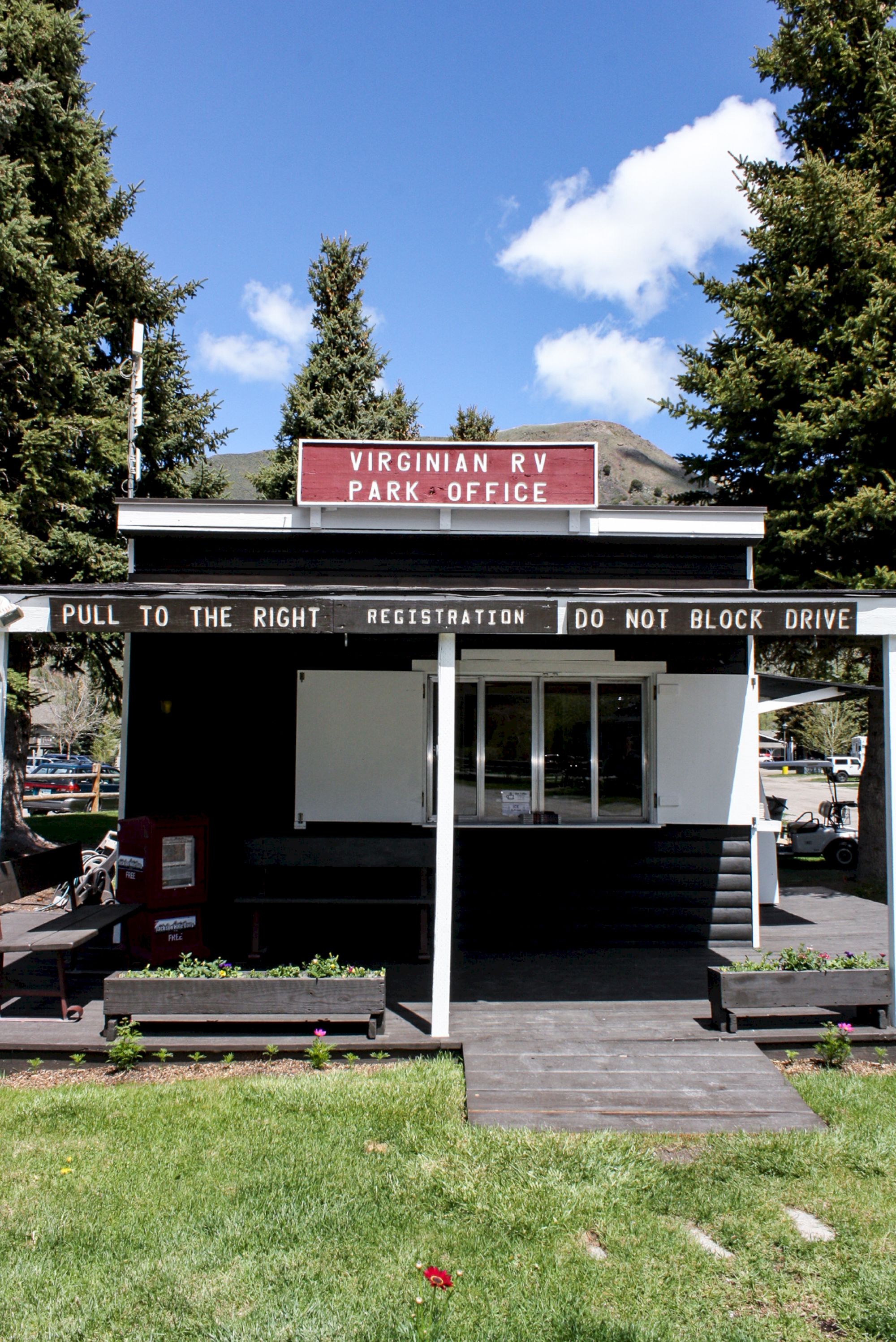 A small building with a sign reading "VIRGINIA M P / PARK OFFICE" and messages "PULL TO THE RIGHT" and "DO NOT BLOCK DRIVE" on the awning.